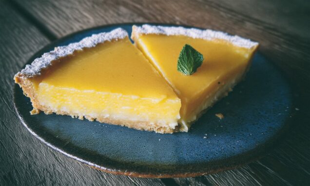 Lagani tart od limuna na plavom keramičkom tanjuru.