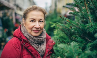 Žena na tržnici kupuje božićnu jelku.