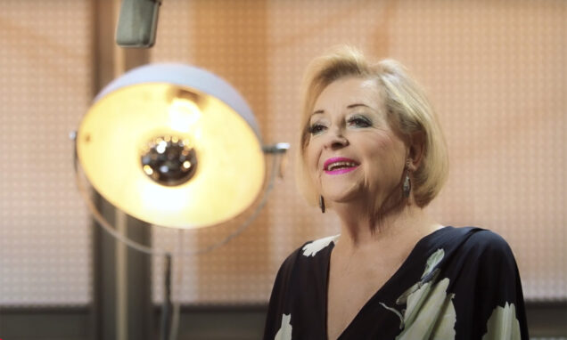 Glazbena diva Gabi Novak u studijskom okruženju – zrači elegancijom, osmijehom i profinjenom prisutnošću pred mikrofonom.