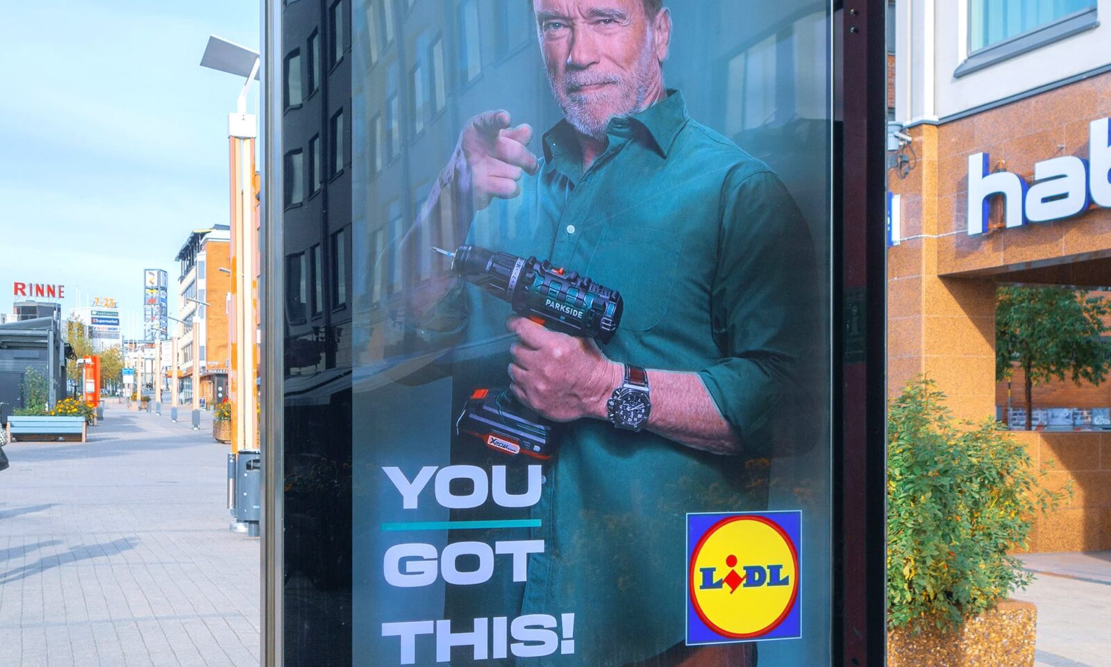 Reklama za Lidl na uličnoj oglasnoj ploči prikazuje Arnolda Schwarzeneggera s bušilicom Parkside u ruci i porukom You got this, promovirajući alate u poznatom maloprodajnom lancu.