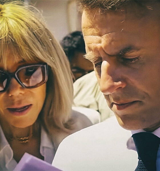 Francuski predsjednik Emmanuel Macron i njegova supruga Brigitte Macron u zajedničkom javnom nastupu, fokusirani na dokument tijekom službenog događanja na otvorenom.