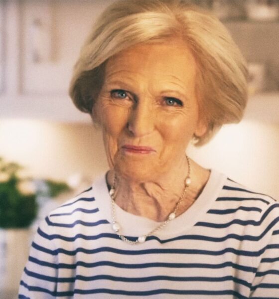 Mary Berry stoji u kuhinji, odjevena u bijelu majicu s plavim prugama, s blagim osmijehom na licu.