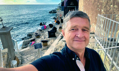 Enver Čišić, umirovljenik, snima selfie uz obalu mora na kamenoj terasi s jastucima i pogledom na Jadran.