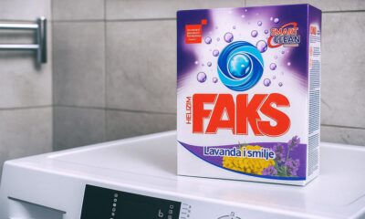 Kutija deterdženta za pranje rublja Faks Helizim s mirisom lavande i smilja, postavljena na perilicu rublja u kupaonici.