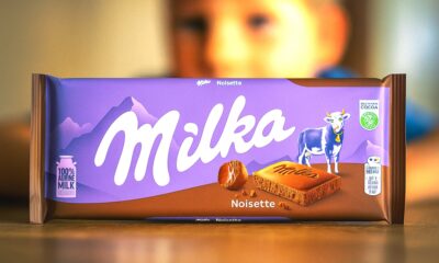 Milka Noisette čokolada na stolu, u pozadini zamućeno dječje lice.