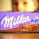 Milka Noisette čokolada na stolu, u pozadini zamućeno dječje lice.
