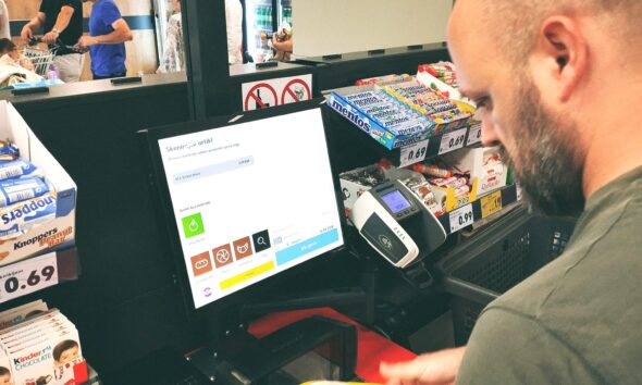 Kupac provlači artikle na samoposlužnoj blagajni.