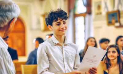 Mladi humanistički krizmanik prima dokument tijekom svečane ceremonije u gradskoj vjećnici.