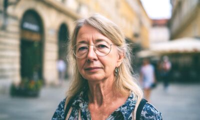 Žena s naočalama gleda u kameru.