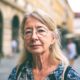 Žena s naočalama gleda u kameru.