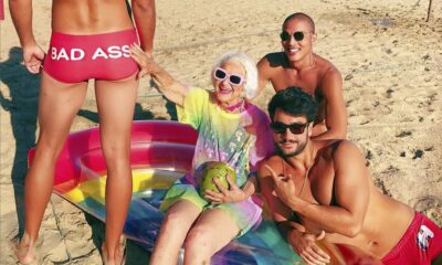 Influencerica Baddie Winkle na plaži, okružena zgodnim mladićima.