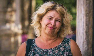 Žena stoji na ulici i gleda u kameru, ljeto je.