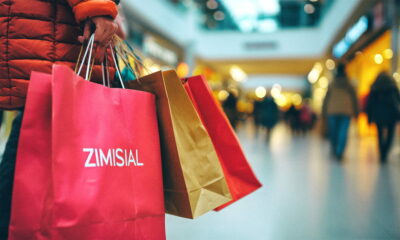 Žena u trgovačkom centru nosi pune ruke vrećica s kupljenom robom.