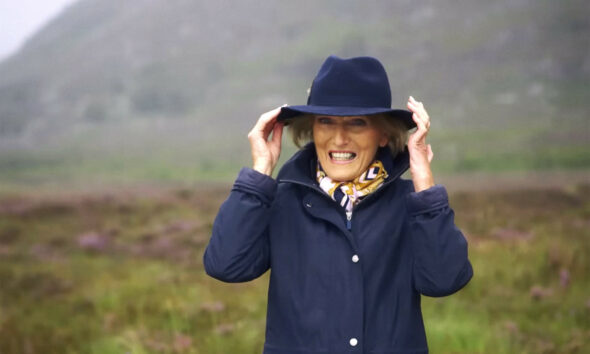 Slavna televizijska kuharica Mary Berry stoji na livadi.