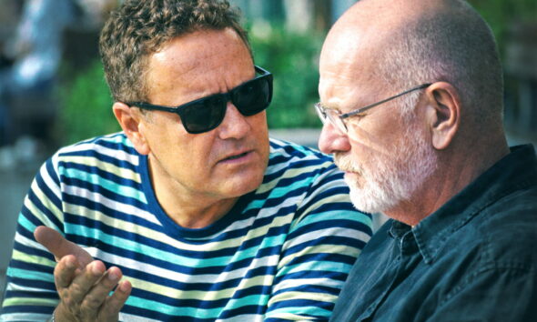 Dvojica prijatelja sjede na klupi i ozbiljno razgovaraju.