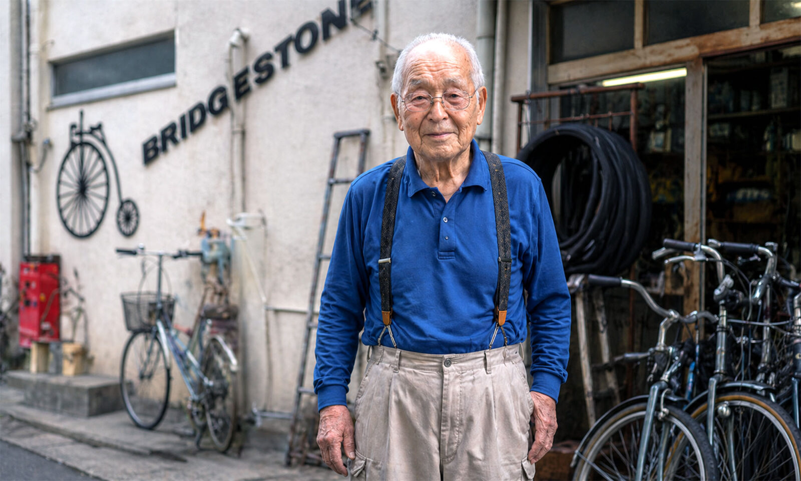 Stariji muškarac u popravljaonici bicikala.