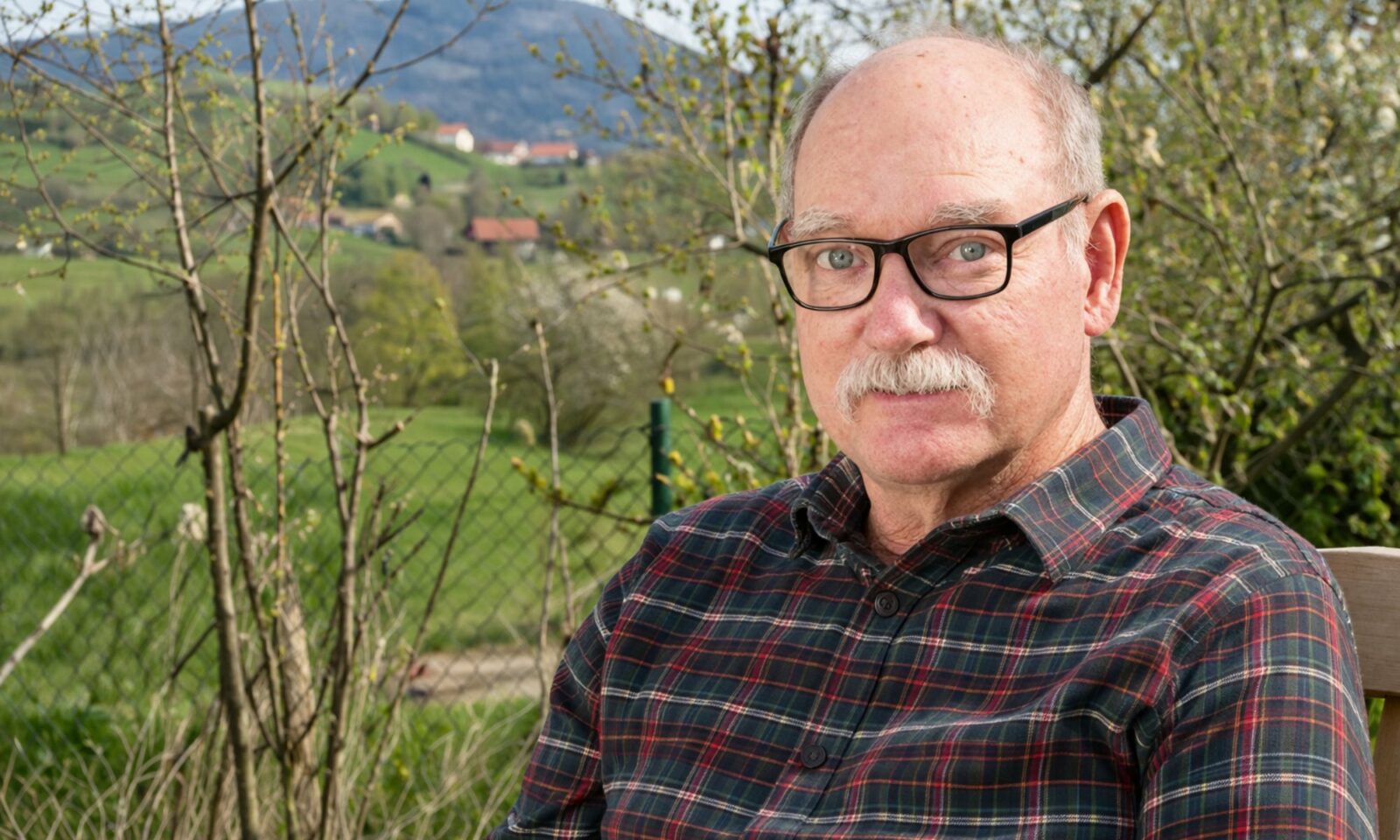 Muškarac u Zagorju, sjedi na trijemu, gleda u kameru.