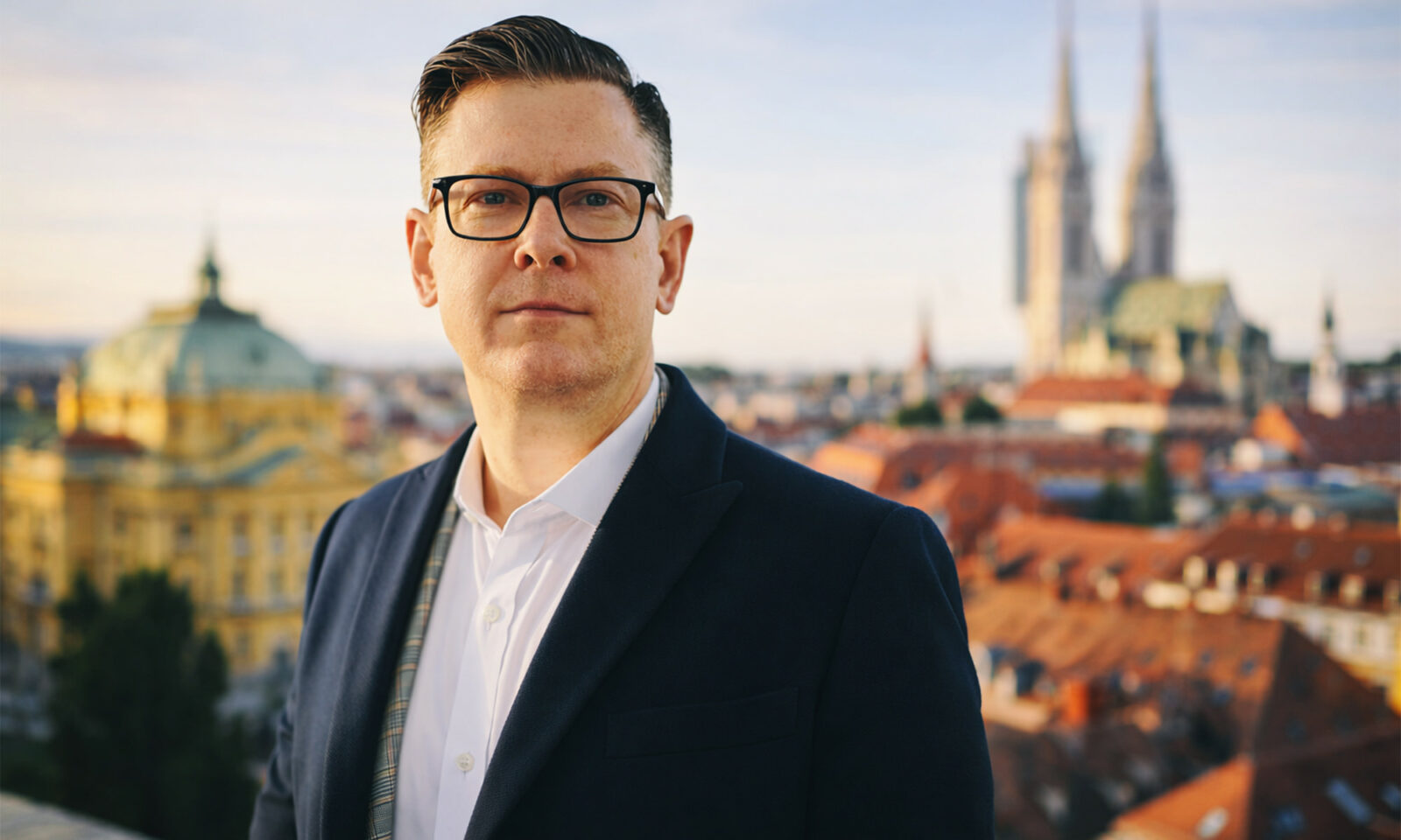 Odvjetnik pozira pred panoramom Zagreba.