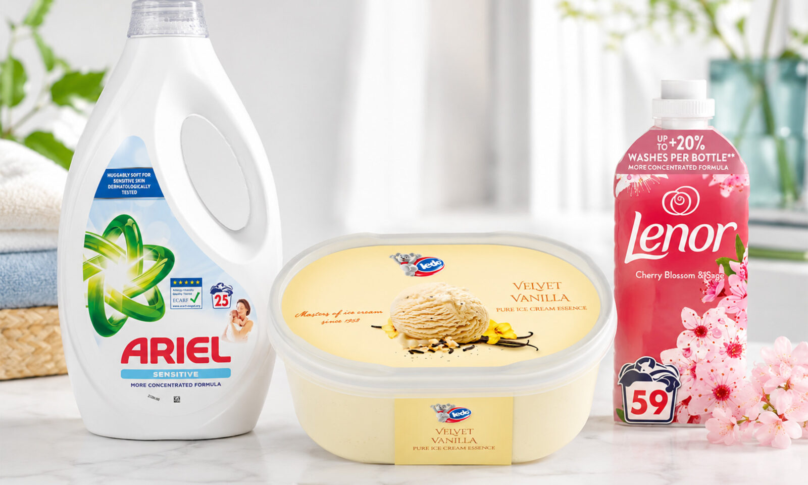 Product photo kućanskih proizvoda na svijetloj podlozi: Ariel Sensitive, Ledo Velvet Vanilla i Lenor Cherry Blossom & Sage u čistom, dobro osvijetljenom interijeru.