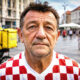 Umirovljenik u dresu hrvatske nogometne reprezentacije stoji na trgu.