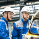 Dvojica radnika na proizvodnoj traci u tvornici automobila.