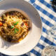 Talijanska tjestenina poslužena na plavom kariranom restoranskom stolnjaku.