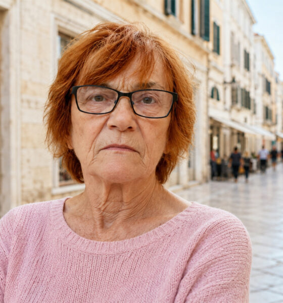 Žena u ružičastoj vesti stoji na Kalelargi u Zadru.