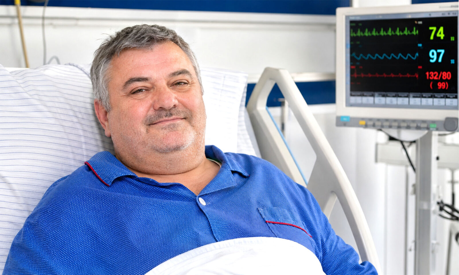 Šezdesetogodišnji muškarac leži u bolničkom krevetu uz monitor koji prikazuje krvni tlak i ostale vitalne znakove.