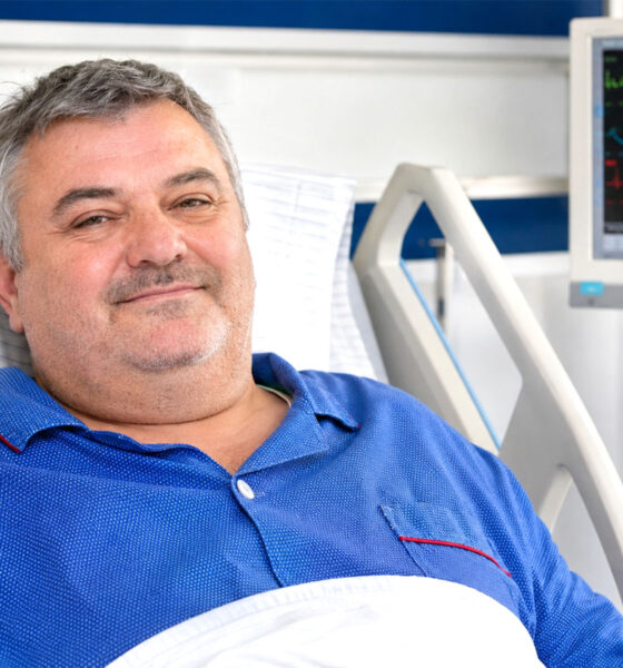 Šezdesetogodišnji muškarac leži u bolničkom krevetu uz monitor koji prikazuje krvni tlak i ostale vitalne znakove.