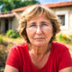 Žena stoji u seoskom dvorištu.