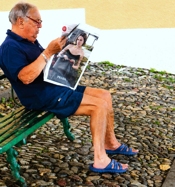 Stariji muškarac čita novine.