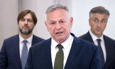Davorko Vidović u prvom planu, dok se u zamućenoj pozadini nalaze premijer Andrej Plenković i ministar financija Tomislav Ćorić.