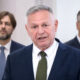 Davorko Vidović u prvom planu, dok se u zamućenoj pozadini nalaze premijer Andrej Plenković i ministar financija Tomislav Ćorić.