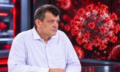Epidemiolog Bernard Kaić ispred zaslona s prikazom virusa i strukture RNK.