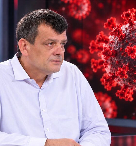 Epidemiolog Bernard Kaić ispred zaslona s prikazom virusa i strukture RNK.