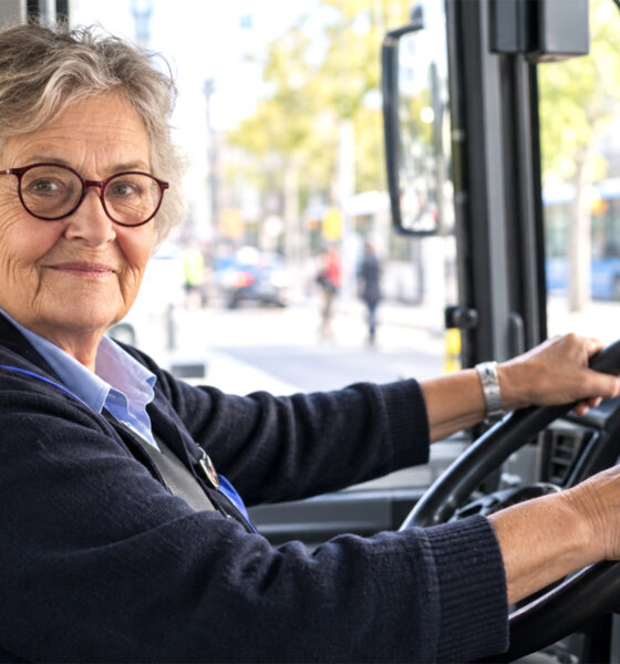 Starija vozačica autobusa za volanom tijekom radnog dana.