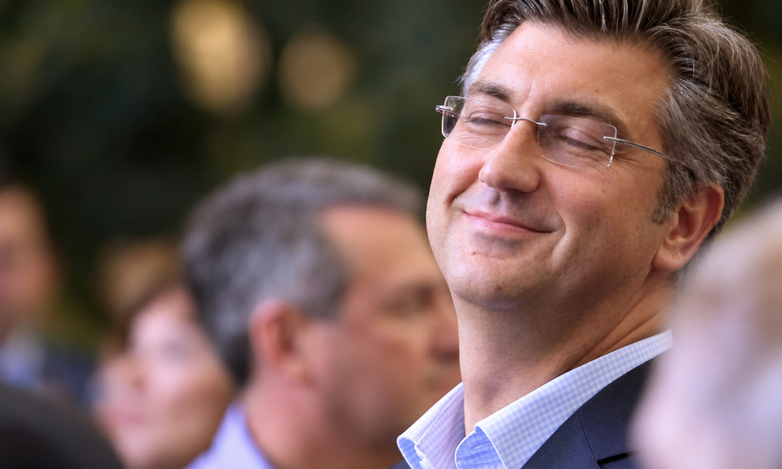 Andrej Plenković zatvorenih očiju i s blagim osmijehom na licu tijekom javnog događanja.